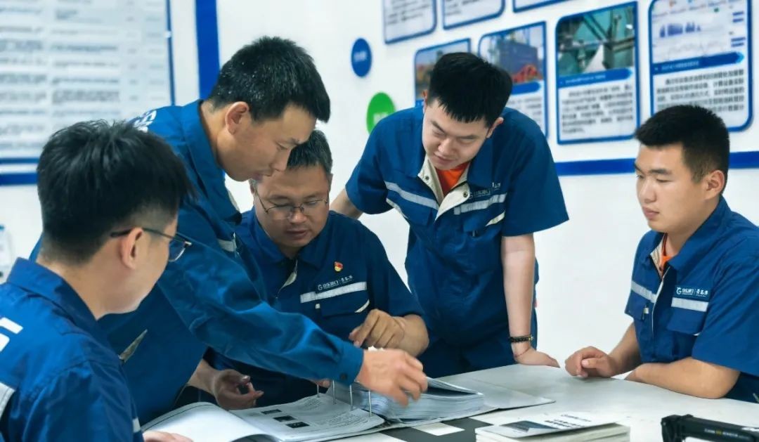 El se&ntilde;or Song (izquierda 3) con sus colegas discutiendo la posibilidad de una soluci&oacute;n en una reuni&oacute;n.